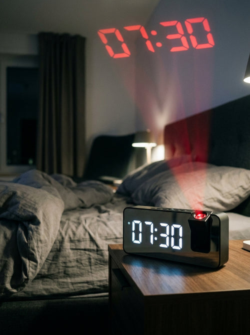 Reloj proyector en la mesa de noche con la hora proyectada en el techo